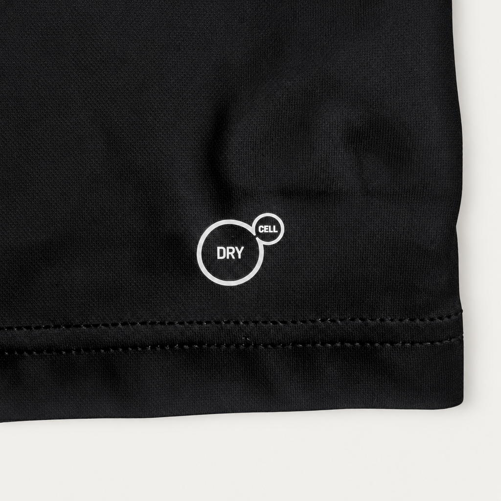 Close-up of a black fabric garment corner with white circular 'DRY' and 'pet' text/logo printed on the fabric, shown against a light neutral background.